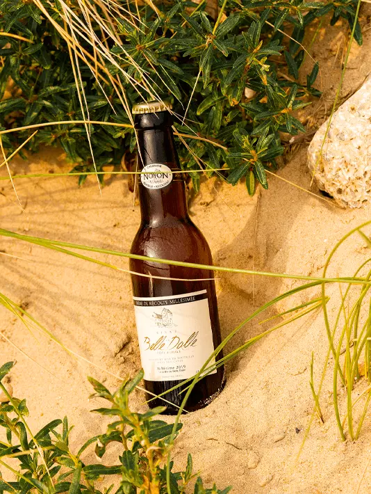 Une bouteille de bière Noyon dans le sable